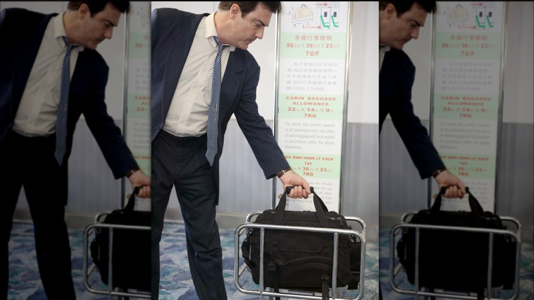 Person fitting bag in holder