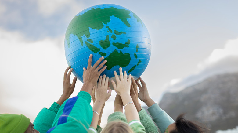 people holding up a globe