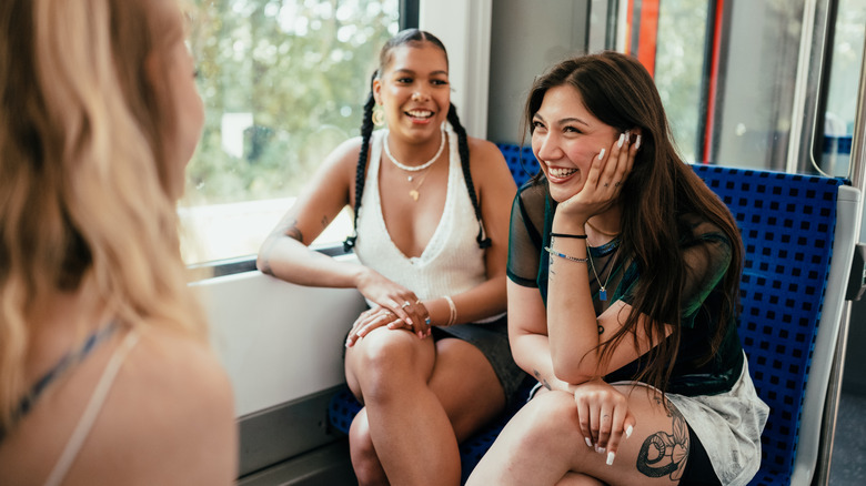 friends laughing while riding public transportation