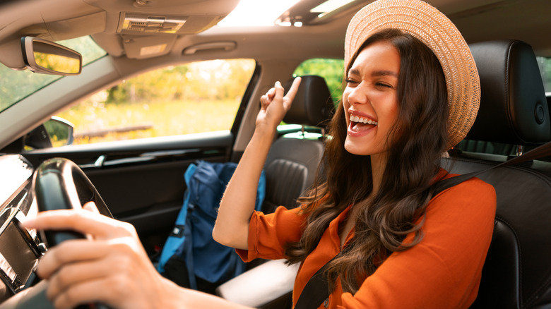 woman driving rental car and singing