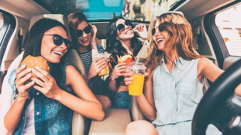 friends in car enjoying food