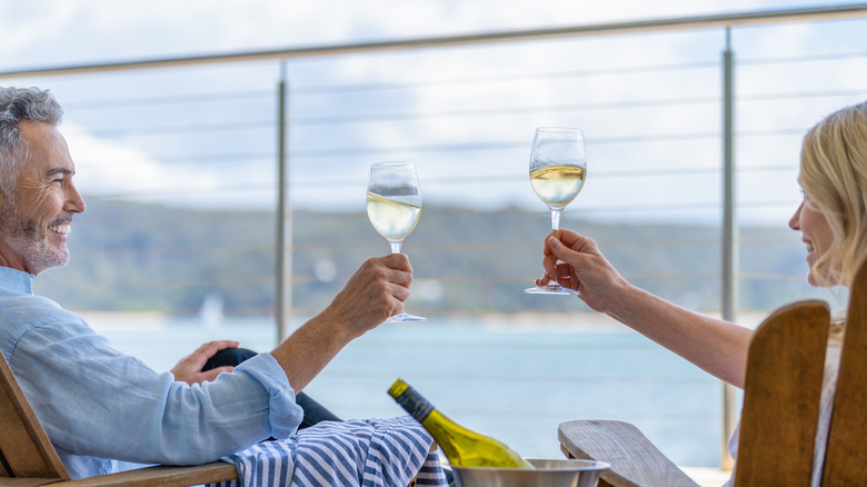 A couple on a ship toasting with wine glasses