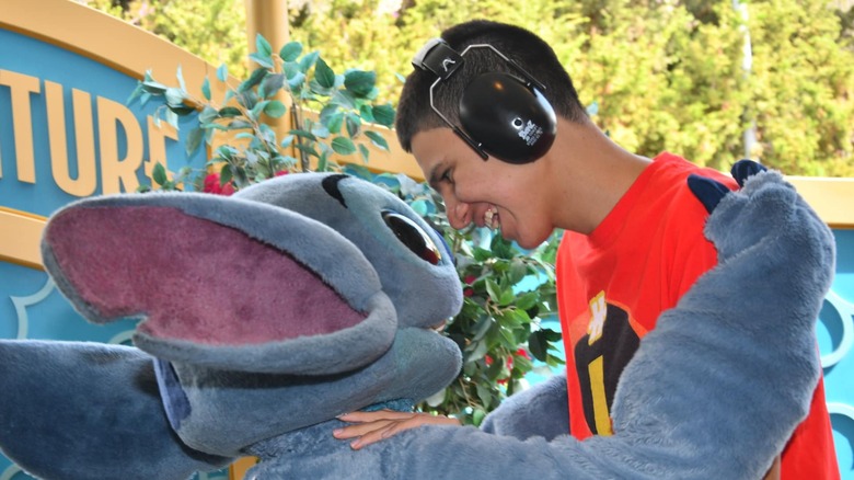 Stitch hugs smiling teen with headphones
