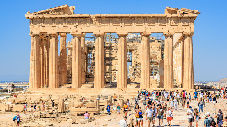 a crowd of tourists around the Parthenon