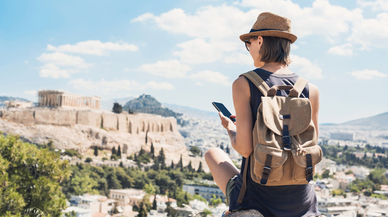 traveler using her phone while exploring Greece