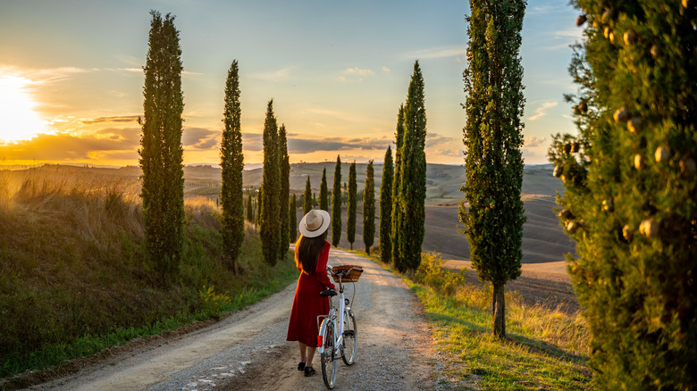 woman bikes through Tuscan landscape