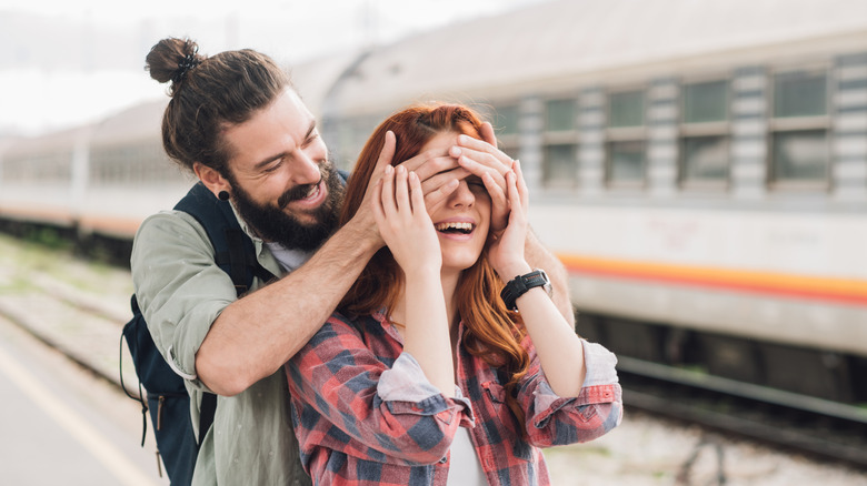 Man surprising his girlfriend at train station