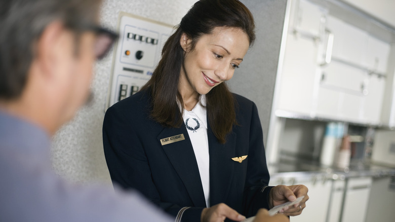 flight attendant checking boarding pass