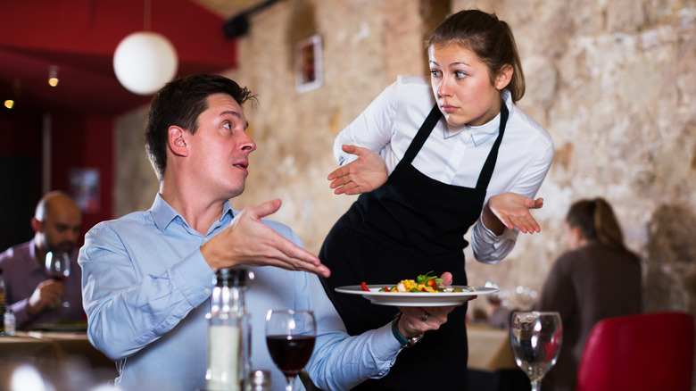 a man expressing displeasure with his meal in a restaurant