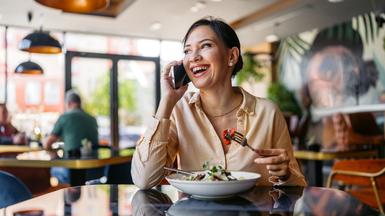 a woman talking on her cellphone in a restaurant