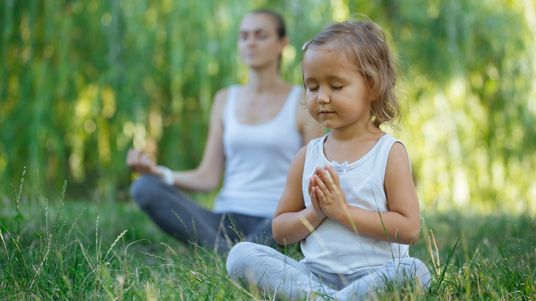 mother and child meditating in a garden