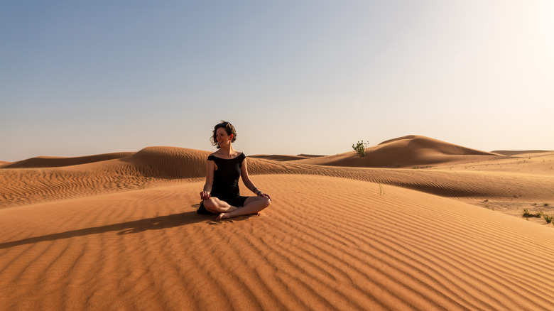 woman meditating in dessert