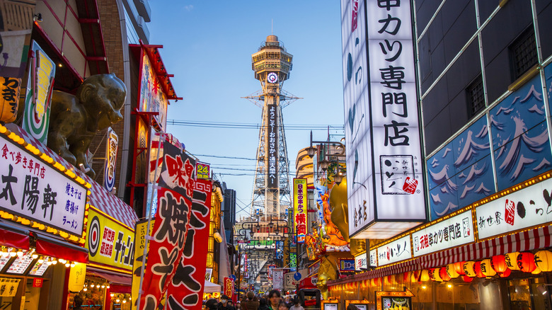 Tsutenkaku Tower, in Osaka, Japan amongst street vendors and bright signs