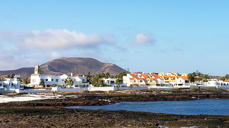 A volcanic crater behind white buildings