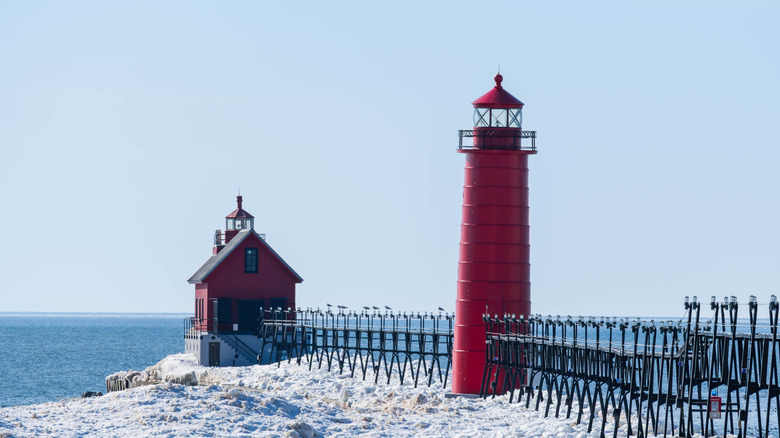 Grand Haven pier and lighthouses covered in ice on a sunny winter day