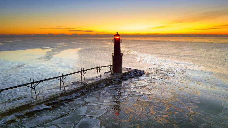 Amazing icy scenic harbor with lighthouse, Lake Michigan in winter