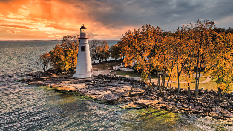 Lighthouse and fall colors on trees on lakeshore