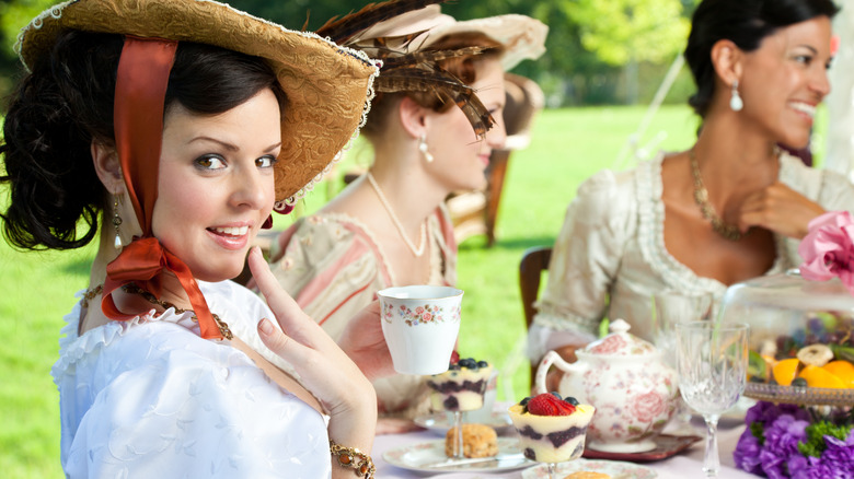 elegantly dressed women having tea