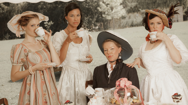 finely dressed women sipping tea with pinkies out