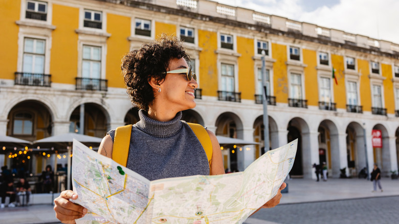 Smiling tourist is holding a map