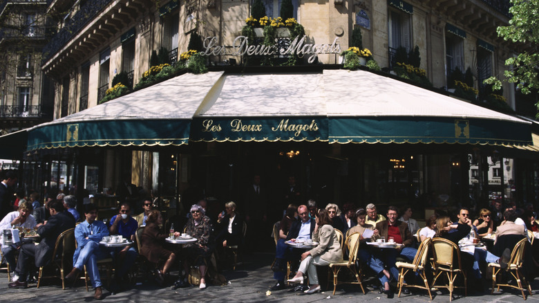 People sitting outside a traditional cafe/bistro in France