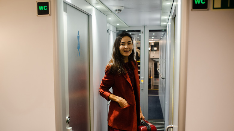 Woman waiting outside the toilet on a train