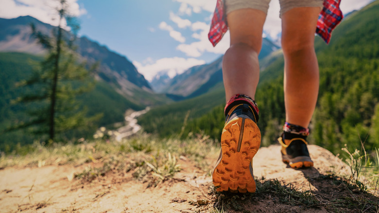 Closeup on the feet of a person hiking on a mountain.