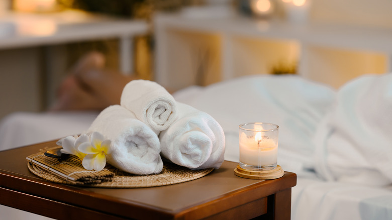 White rolled-up towels and a candle inside a luxury spa