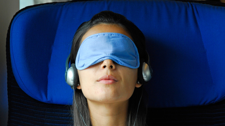woman sleeping on train in eyemask