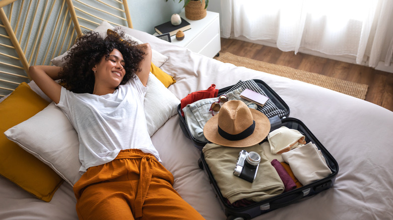 happy woman near open suitcase