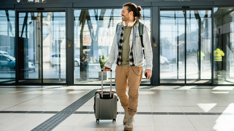 A happy traveler with a suitcase.