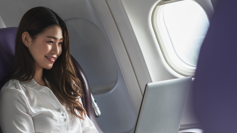 happy female traveler with computer