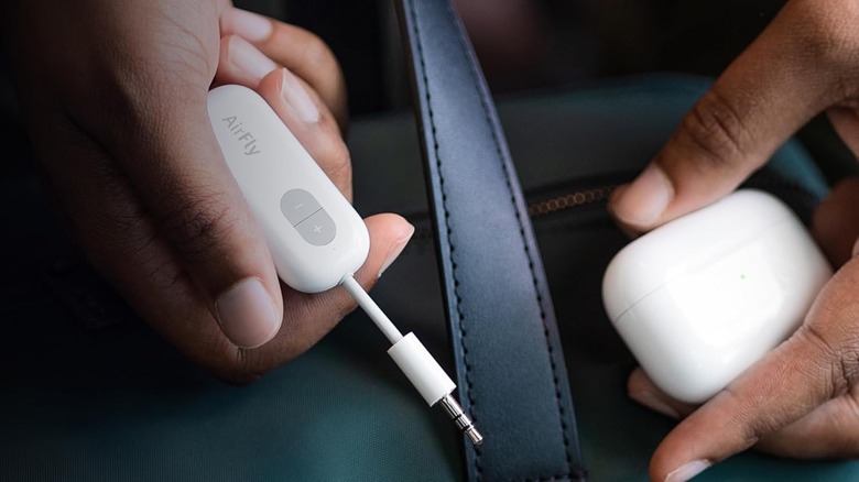 Hands holding Twelve South Airfly bluetooth adapter.