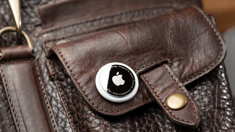 An Airtag on a brown leather bag.