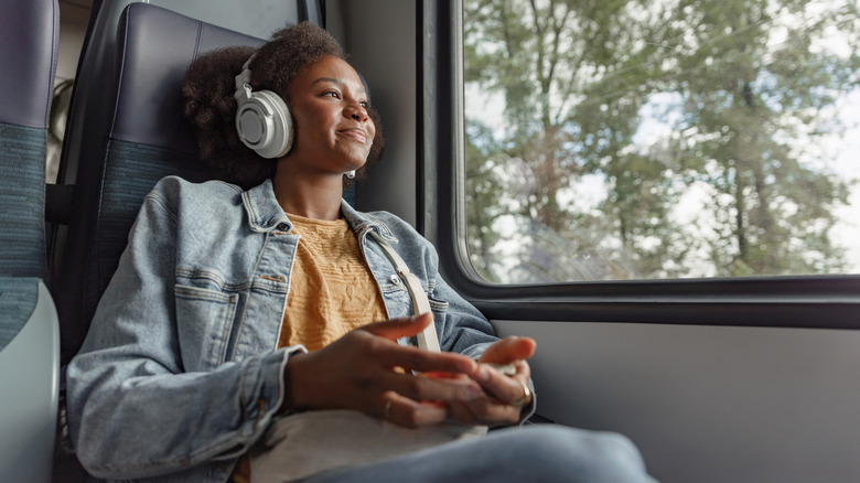 Young woman wearing headphones on a train