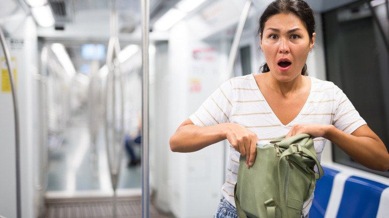Lady looking shocked after discovering a theft from her bag on a train