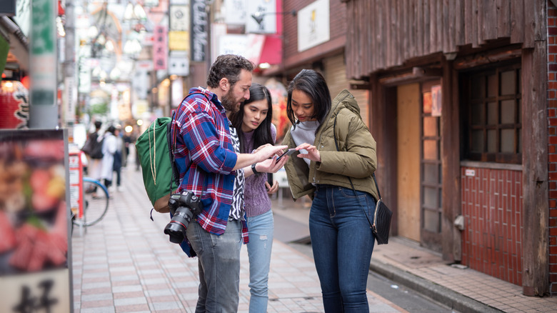 a couple asking for directions from a local woman