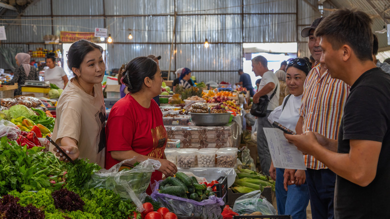 foreigners at a local market try to communicate in another language