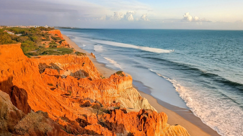 Orange cliffs and rolling waves on Praia da Falésia