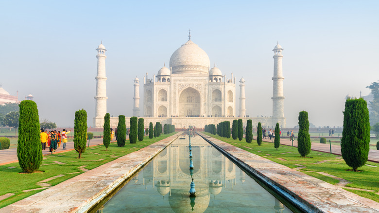 The Taj Mahal reflected in an artificial pool on a clear morning in Agra, India