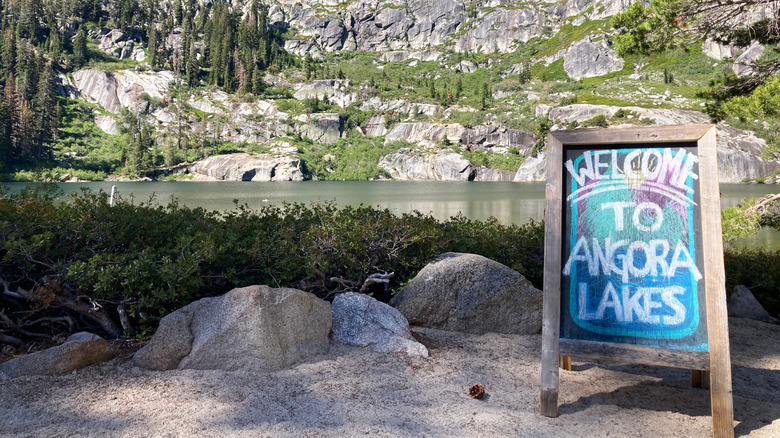 Welcome sign chalkboard with lake and granite cliffs in background