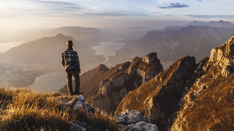 A hiker gazes from the top of a mountain at Lake Como, Italy