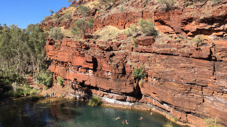 Swimming hole surrounded by red sandstone cliffs
