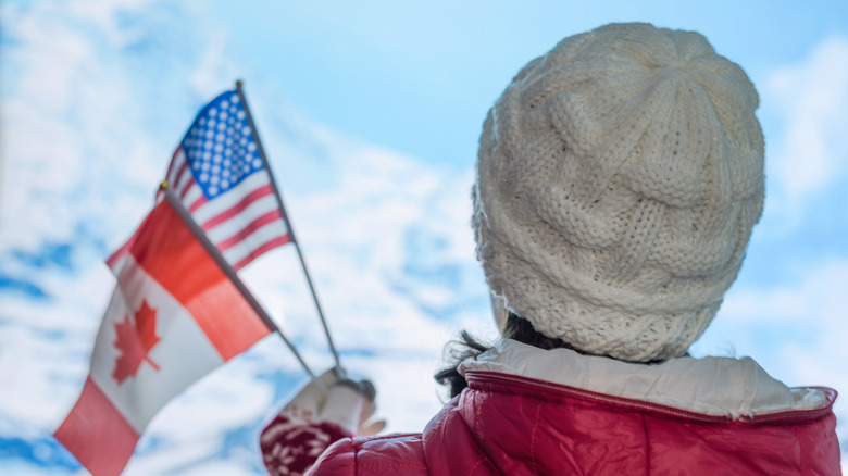 Person holding Canadian and US flags