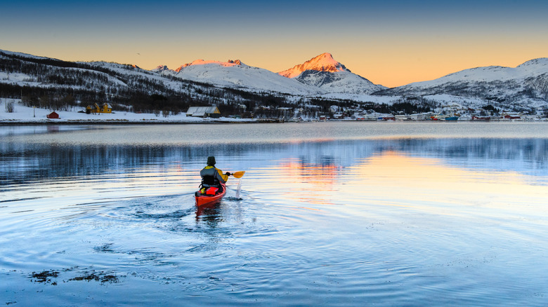 Kayak with snow-covered mountains at sunset