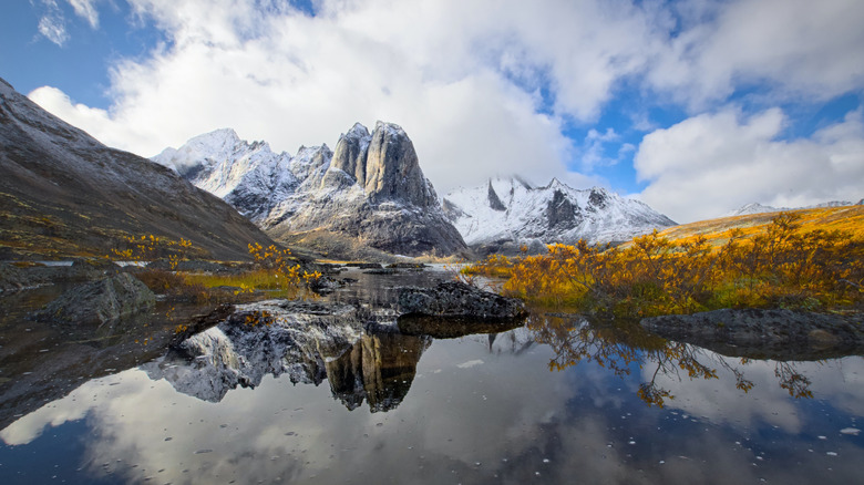 mountain and golden tundra reflected in lake