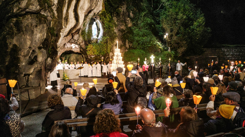 religious service in cave with Mary statue