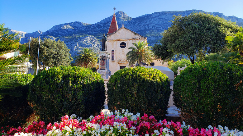 Old Town square with flowers, church and mountains