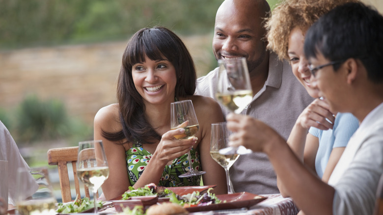 People enjoying wine and food.