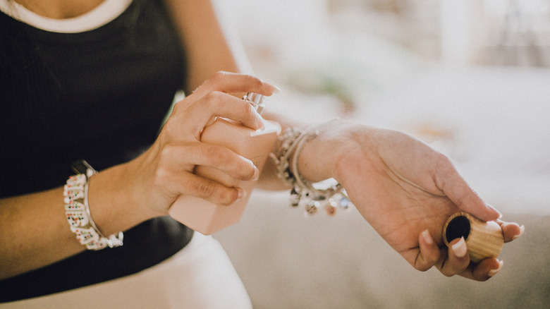 Woman applying perfume on wrist